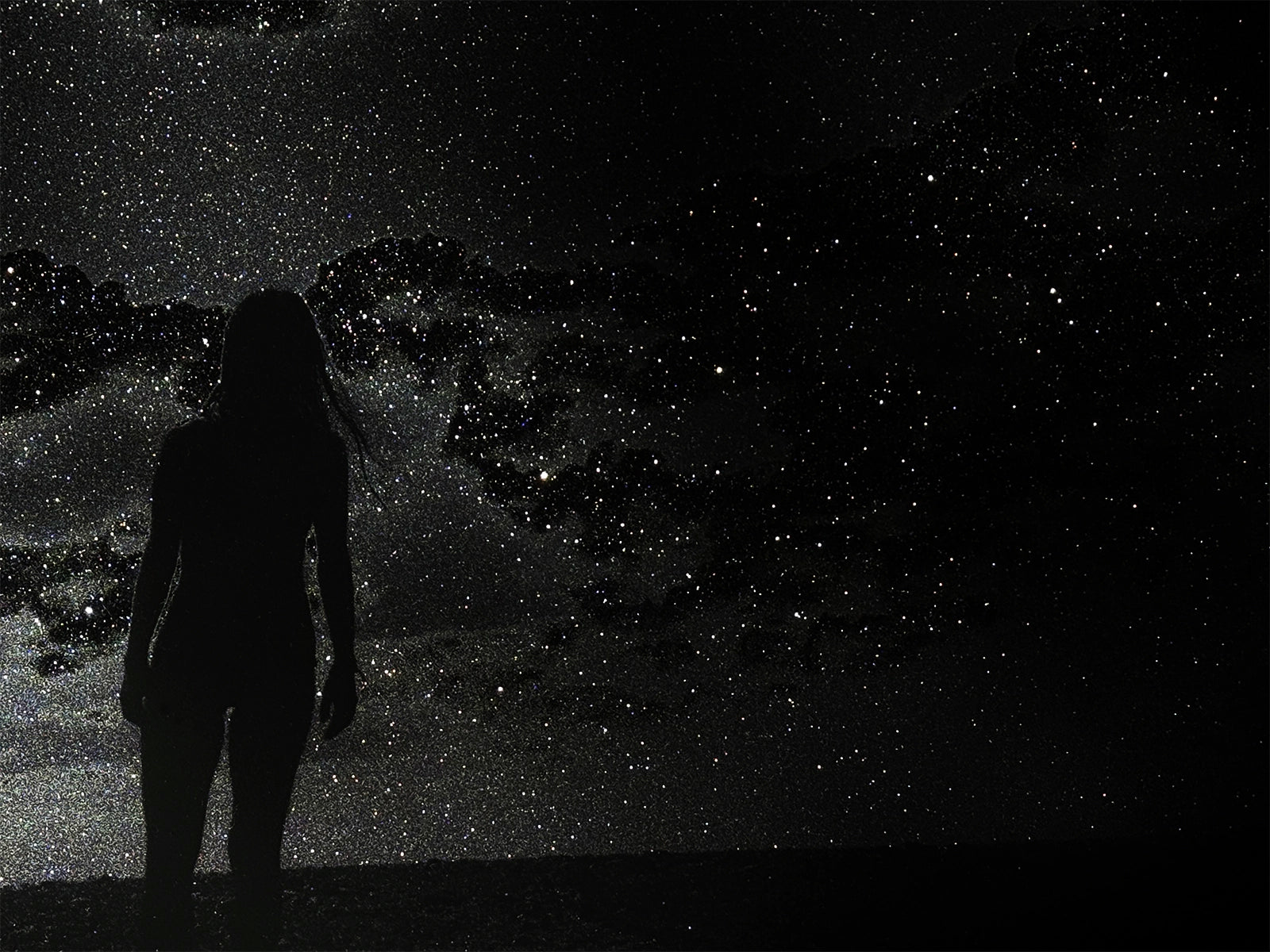 Silhouette of a person against a starry night sky