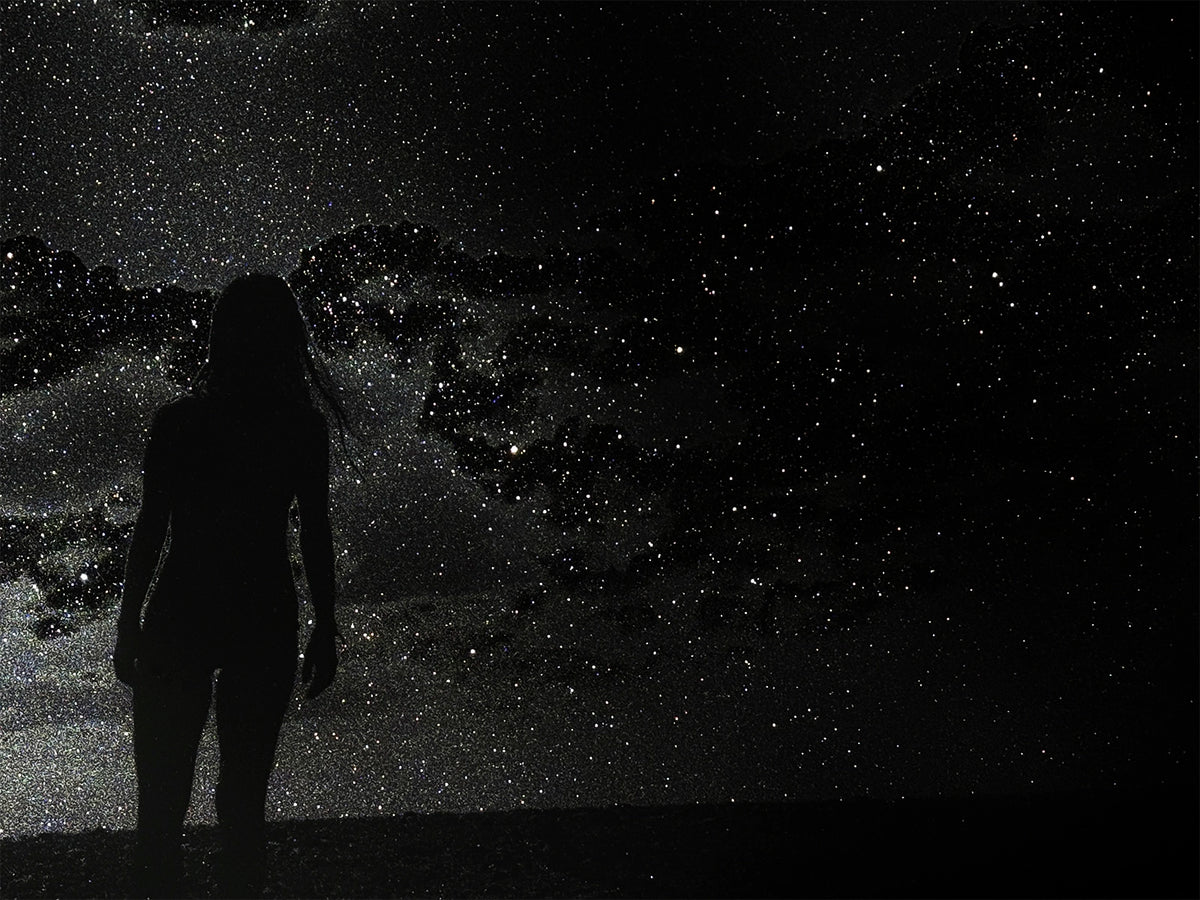 Silhouette of a person against a starry night sky